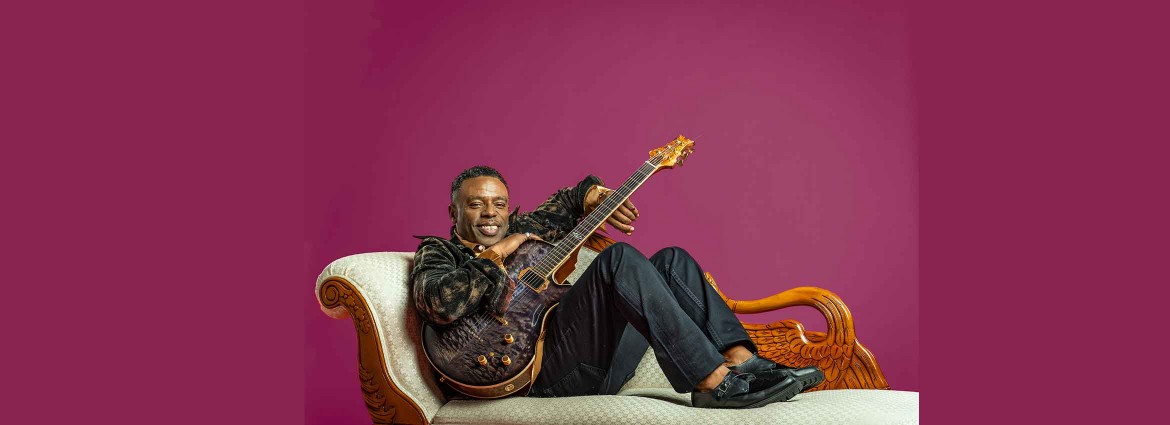 Norman Brown sitting with guitar