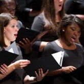 Members of the Buffalo State Chamber Choir performing on stage.