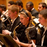 Three members of the Buffalo State Wind Ensemble playing the saxophone.